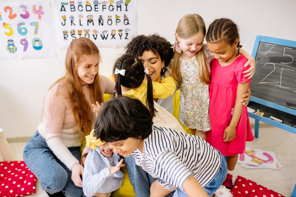 Why Building Relationships in Early Childhood Shapes a Child’s Future 3 Happy preschoolers and teacher bonding in a colorful classroom setting, fostering friendship and education.